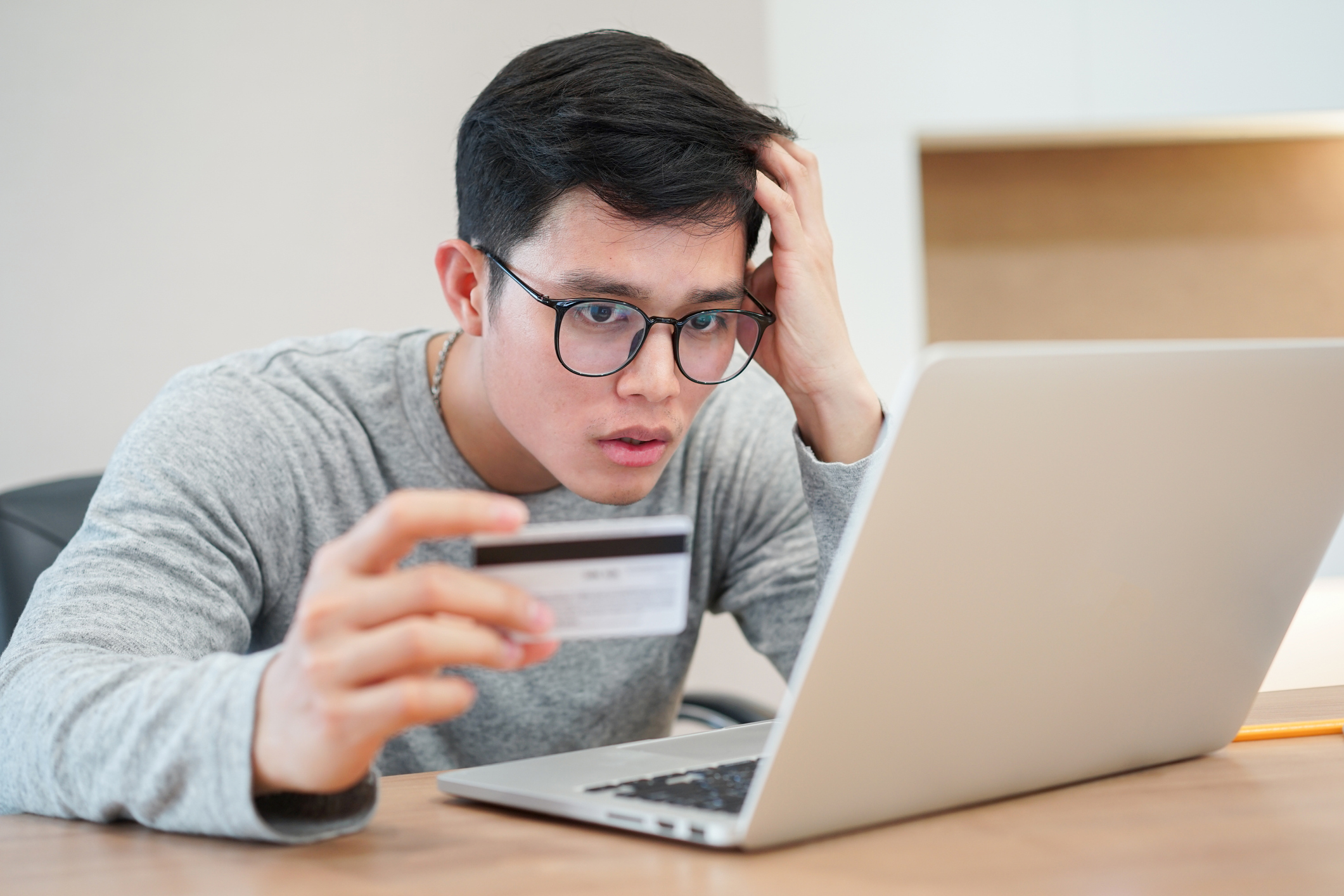 close up on young asian man feeling shock after make payment by credit card but website e